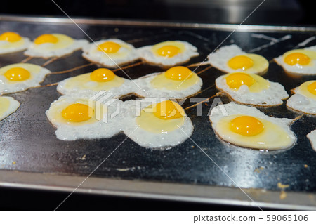 the Cook prepares the eggs in the kitchen of the restaurant the Cook prepares the eggs in the kitchen of the restaurant 59065106