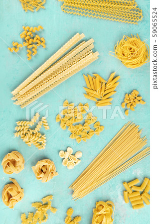 Italian pasta flat lay poster, shot from above on a blue background. Spaghetti, penne, farfalle and 59065524