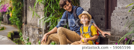 Father and son tourists in Bali walks along the narrow cozy streets of Ubud. Bali is a popular 59065596