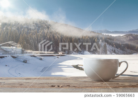 Single tea or coffee cup and landscape of mountains on background Single tea or coffee cup and landscape of mountains on background 59065663