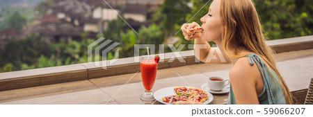Woman eating delicious strawberry pizza on a balinese tropical nature background. Bali island 59066207