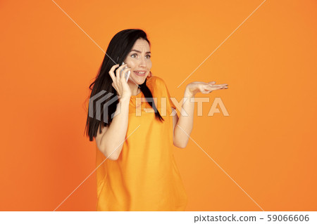Caucasian young woman's portrait on orange background Caucasian young woman's portrait on orange background 59066606