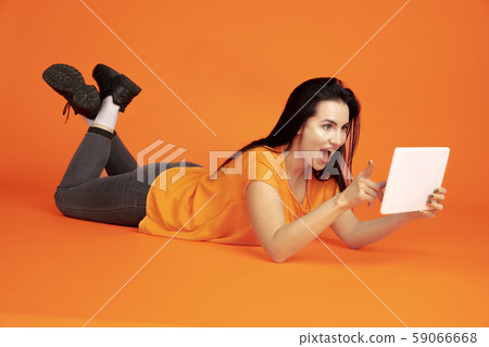 Caucasian young woman's portrait on orange background Caucasian young woman's portrait on orange background 59066668