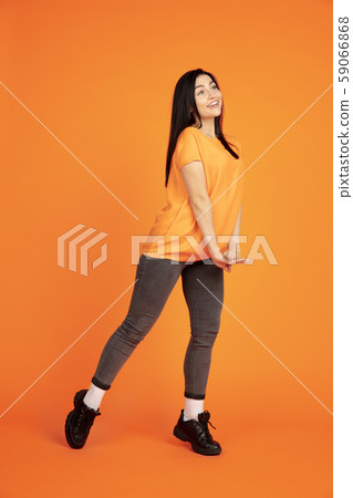 Caucasian young woman's portrait on orange background Caucasian young woman's portrait on orange background 59066868