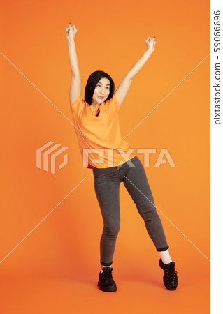 Caucasian young woman's portrait on orange background Caucasian young woman's portrait on orange background 59066896