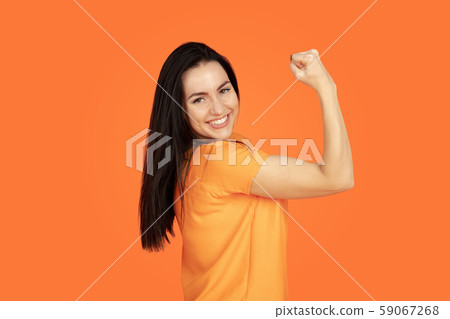 Caucasian young woman's portrait on orange background 59067268