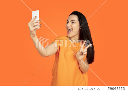 Caucasian young woman's portrait on orange background Caucasian young woman's portrait on orange background 59067353