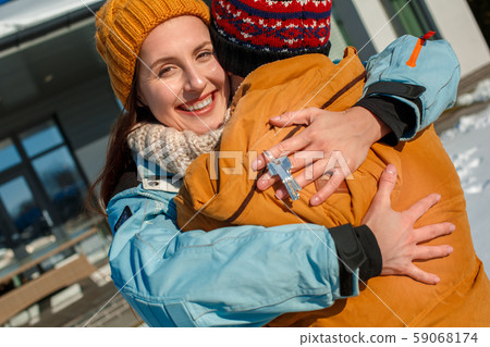 Winter vacation. Young couple standing together outdoors with keys from new apartment smiling happy Winter vacation. Young couple standing together outdoors with keys from new apartment smiling happy 59068174