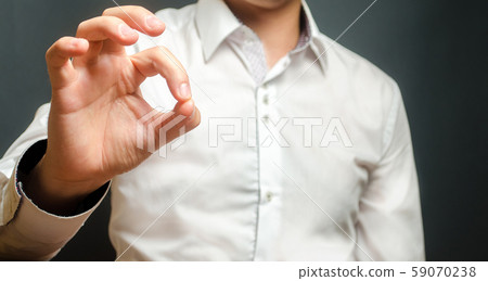 Man shows okay sign with his hand. Approval and consent, acceptance of the terms of the contract. Make a promise to fulfill everything in the best possible way. Responsiveness and help. 59070238