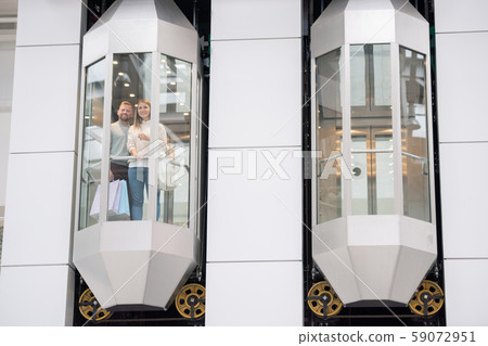 Young dates standing in one of elevators and looking through window 59072951
