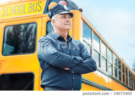 Senior driver standing near school bus crossed arms smiling inspired Senior driver standing near school bus crossed arms smiling inspired 59073900