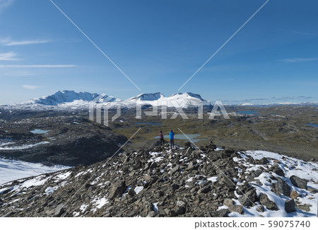 Two hikers couple admiring view from foot of 59075740