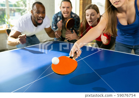 Young people playing table tennis in workplace, having fun Young people playing table tennis in workplace, having fun 59076754