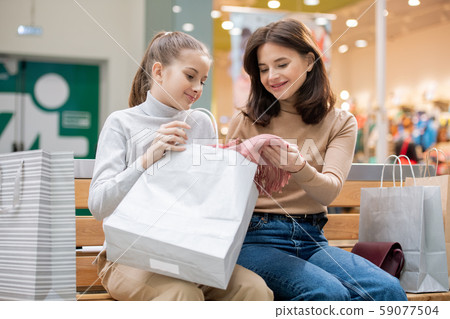 Cute girl and her mother discussing new pink scarf that they bought on sale Cute girl and her mother discussing new pink scarf that they bought on sale 59077504