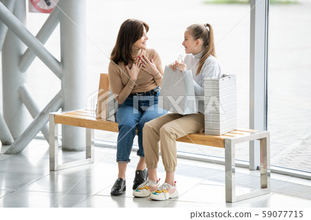 Cheerful females in casualwear discussing something curious while having rest 59077715