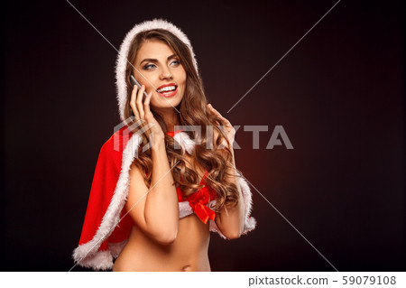 Christmas and New Year. Woman in santa costume with hood standing isolated on black talking on Christmas and New Year. Woman in santa costume with hood standing isolated on black talking on 59079108