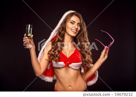 Christmas and New Year. Woman in santa costume with hood standing isolated on black holding fancy Christmas and New Year. Woman in santa costume with hood standing isolated on black holding fancy 59079232