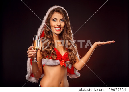 Christmas and New Year. Woman in santa costume with hood standing isolated on black with glass of Christmas and New Year. Woman in santa costume with hood standing isolated on black with glass of 59079234
