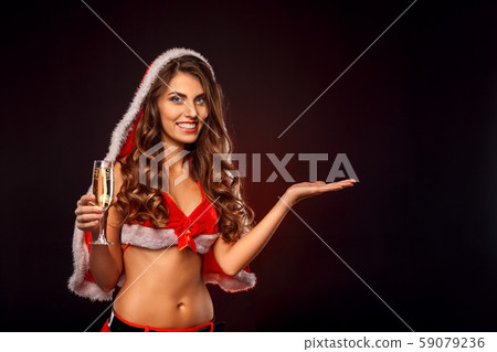 Christmas and New Year. Woman in santa costume with hood standing isolated on black with glass of Christmas and New Year. Woman in santa costume with hood standing isolated on black with glass of 59079236