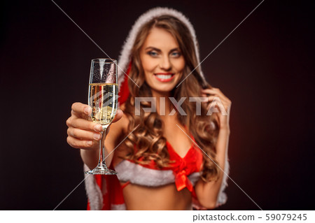Christmas and New Year. Woman in santa costume with hood standing isolated on black with glass of Christmas and New Year. Woman in santa costume with hood standing isolated on black with glass of 59079245