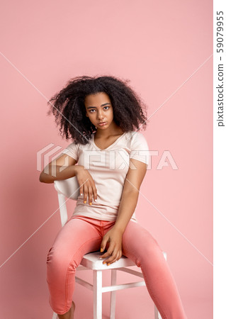 Freestyle. African girl sitting on chair isolated on pink posing cute Freestyle. African girl sitting on chair isolated on pink posing cute 59079955