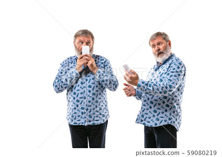Senior man arguing with himself on white studio background. 59080219