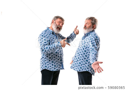 Senior man arguing with himself on white studio background. Senior man arguing with himself on white studio background. 59080365