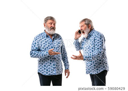 Senior man arguing with himself on white studio background. Senior man arguing with himself on white studio background. 59080429