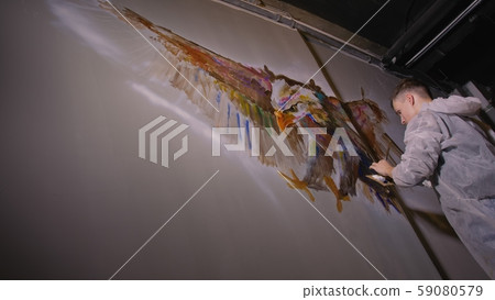 Artist designer draws an eagle on the wall. Craftsman decorator paints picture with acrylic oil 59080579