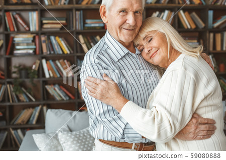 Senior couple together at home retirement concept standing head on shoulder 59080888