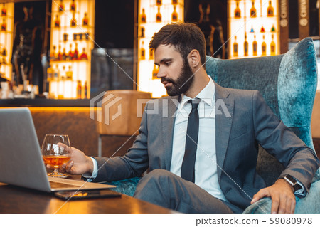 Businessman sitting in a business center bar drinking thinking 59080978