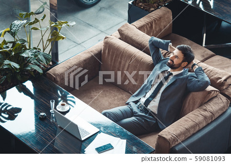 Businessman sitting in a business center restaurant rest on the sofa top view Businessman sitting in a business center restaurant rest on the sofa top view 59081093