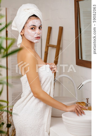Woman is applying mask on her face 59082063