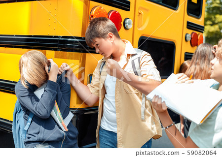 Children going to school by bus boys bullying classmate aggressive close-up 59082064