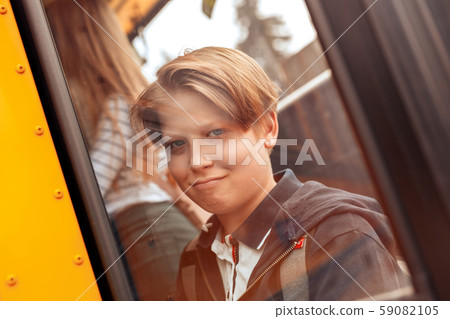 Classmates going to school by bus boy behind window close-up grimace joyful Classmates going to school by bus boy behind window close-up grimace joyful 59082105