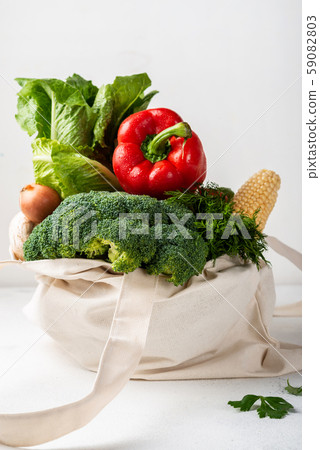 Fabric eco bag full of different fresh vegetables on a light background. Zero waste purchases 59082803