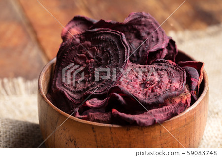 Close-up homemade healthy beetroot chips in wooden bowl. Natural healthy vegetable snack. Alternative to ready-made chips. Top view. Close-up homemade healthy beetroot chips in wooden bowl. Natural healthy vegetable snack. Alternative to ready-made chips. Top view. 59083748