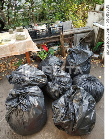 Black bags with trash on the street in the yard 59085639