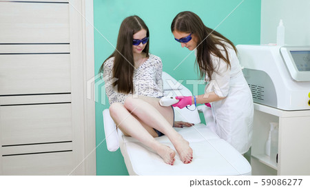 therapist in white coat puts on purple sterile gloves therapist in white coat puts on purple sterile gloves 59086277
