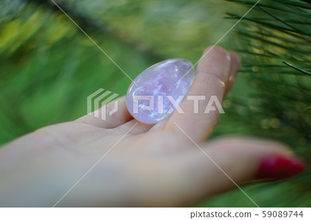 Female hand with transparent amethyst quartz yoni egg for vumfit, imbuilding or meditation. Shining Female hand with transparent amethyst quartz yoni egg for vumfit, imbuilding or meditation. Shining 59089744