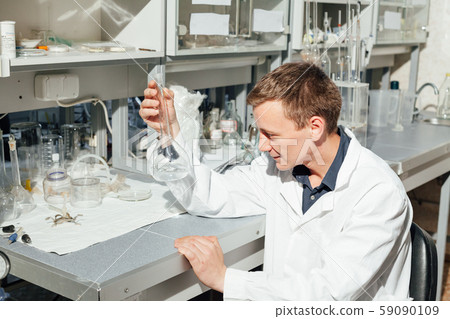 scientist in the medical laboratory conducts chemical experiments with liquids scientist in the medical laboratory conducts chemical experiments with liquids 59090109