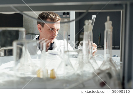 scientist in the medical laboratory conducts chemical experiments with liquids scientist in the medical laboratory conducts chemical experiments with liquids 59090110