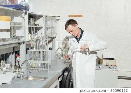scientist in the medical laboratory conducts chemical experiments with liquids scientist in the medical laboratory conducts chemical experiments with liquids 59090112