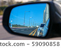 A road reflected in a rearview mirror 59090858