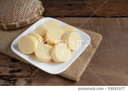 sliced of egg tofu in a ceramic dish on wooden table prepare to cook, close up. sliced of egg tofu in a ceramic dish on wooden table prepare to cook, close up. 59091977