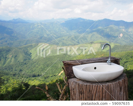 white ceramics wash basin with stainless steel faucet on natural wood log on mountain top with real luxury tropical hills and mountain view white ceramics wash basin with stainless steel faucet on natural wood log on mountain top with real luxury tropical hills and mountain view 59097635