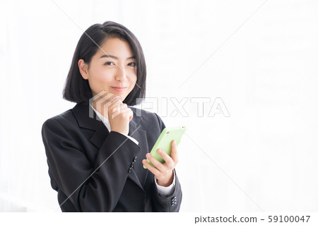 Woman business watching smartphone 59100047