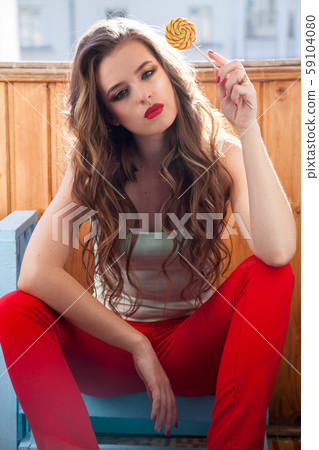 Beautiful woman eats a big candy sweet lollipop 59104080