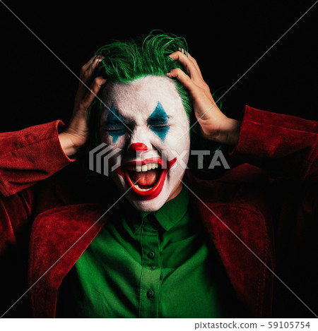 Make-up Joker with green hair for Halloween. Close-up face on black background. Make-up Joker with green hair for Halloween. Close-up face on black background. 59105754