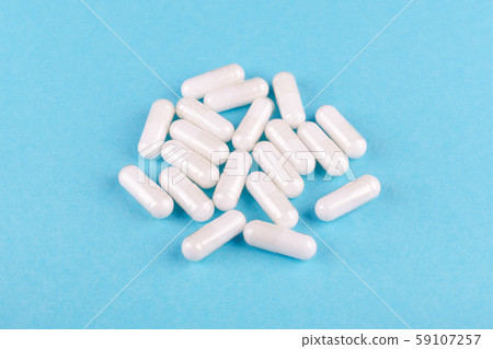 food supplement capsules on blue background closeup 59107257